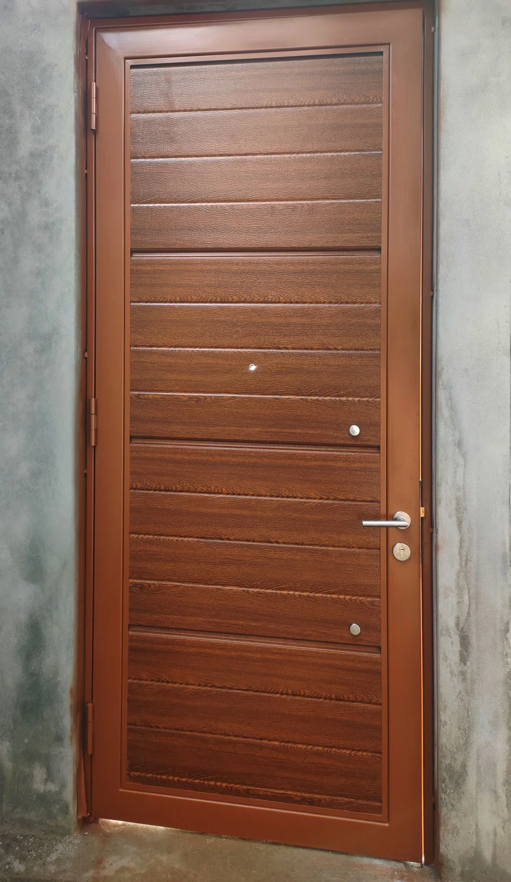 Puerta de acero enchapada acabado cedro instalada en residencia.