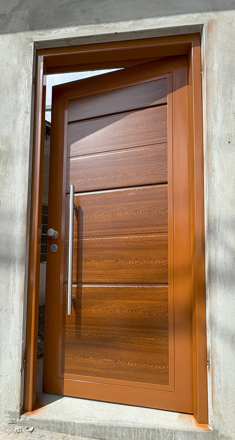 Puerta peatonal a juego con porton de garaje acabado madera instalada en residencia.