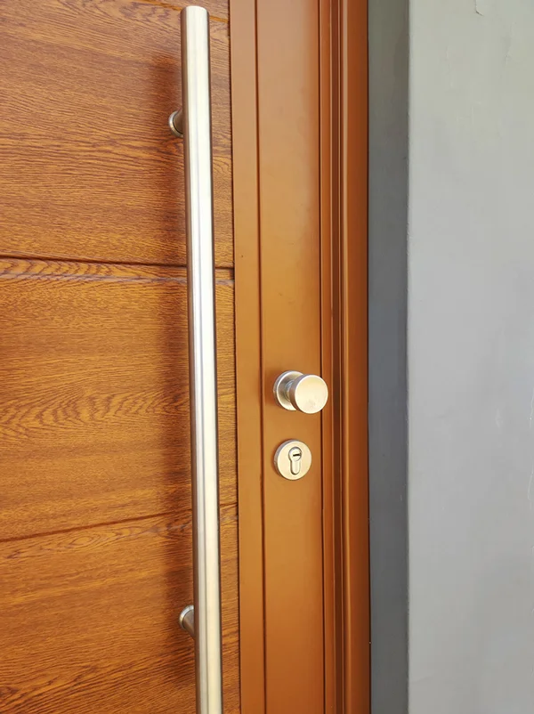 Puerta principal acabado madera clara moderna instalada en residencia.