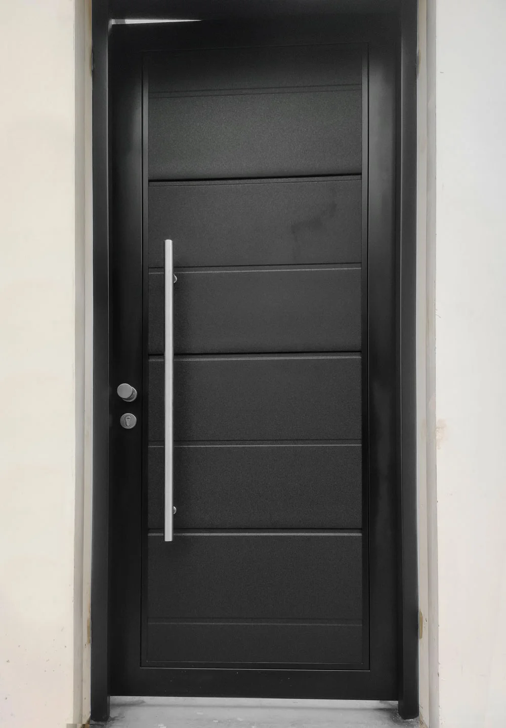 Puerta principal grafito diseno moderno instalada en residencia.