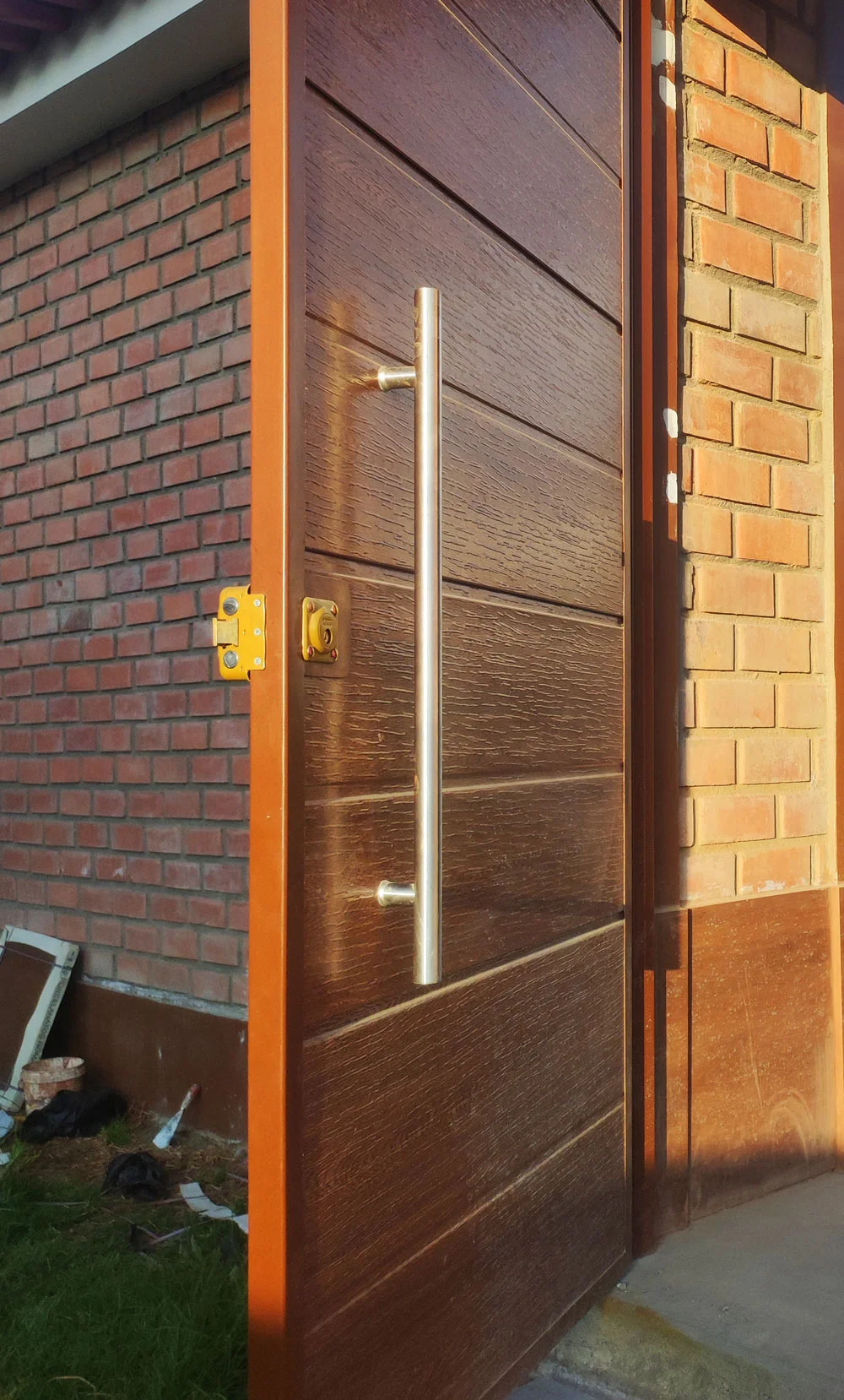 Puerta principal madera abierta vista interior instalada en residencia.