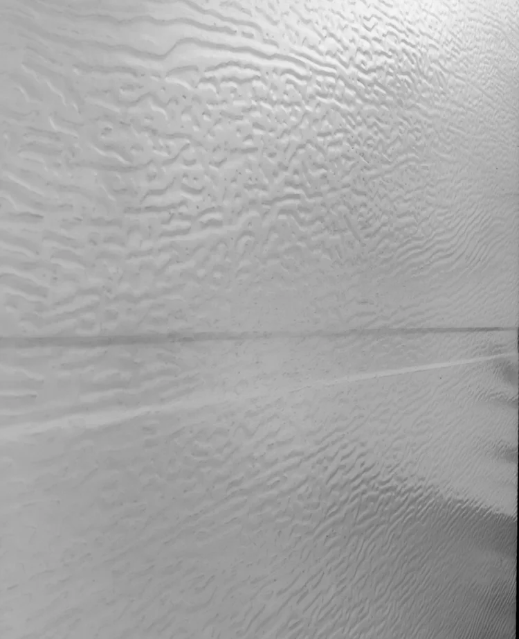 Muestra de panel color blanco con textura de madera para puerta principal moderna.